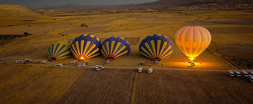Colorful balloons preparing for launch before sunrise